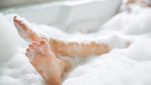 Bare feet rising from luxurious bubble bath