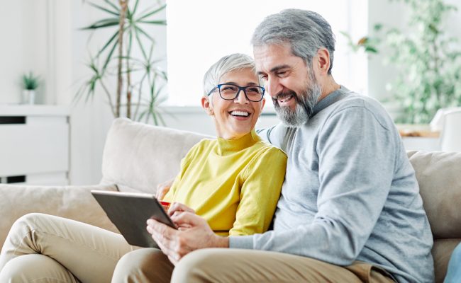 Couple on sofa using wireless internet on an iPad