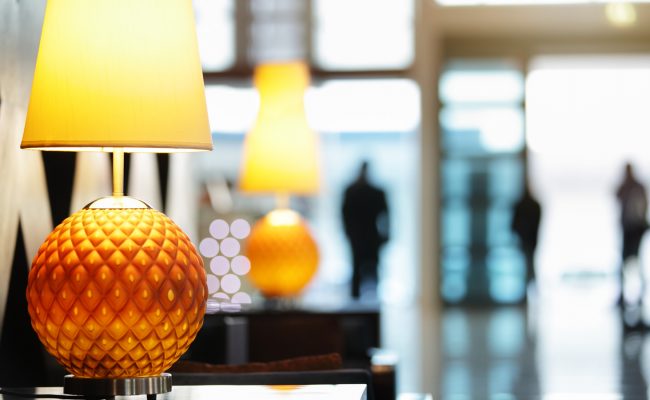 Elegant Entry Lobby: Orange lamps with blurred  figures entering The Bristol in the distance.